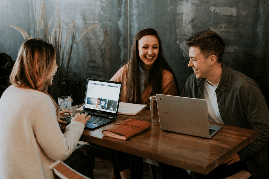 Groep studenten werkt samen aan een laptop aan een tafel